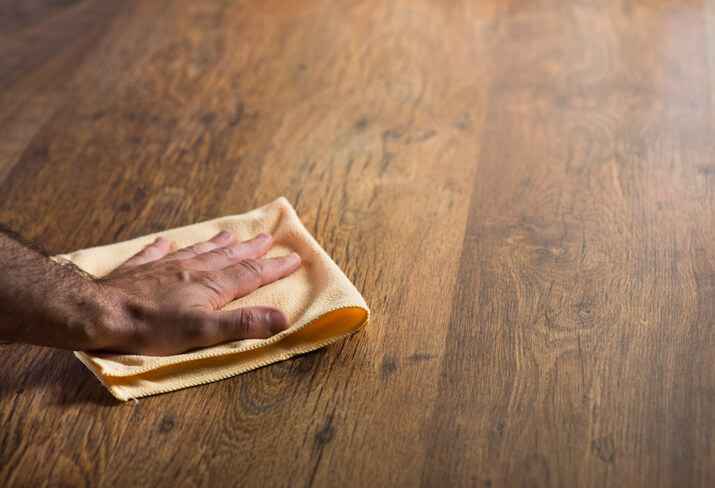 Hand cleaning hardwood floor with a microfiber cloth